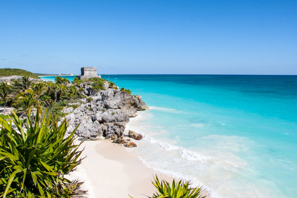 Beautiful beach with turquoise water  in Tulum Mexico, Mayan ruins on top of the cliff.