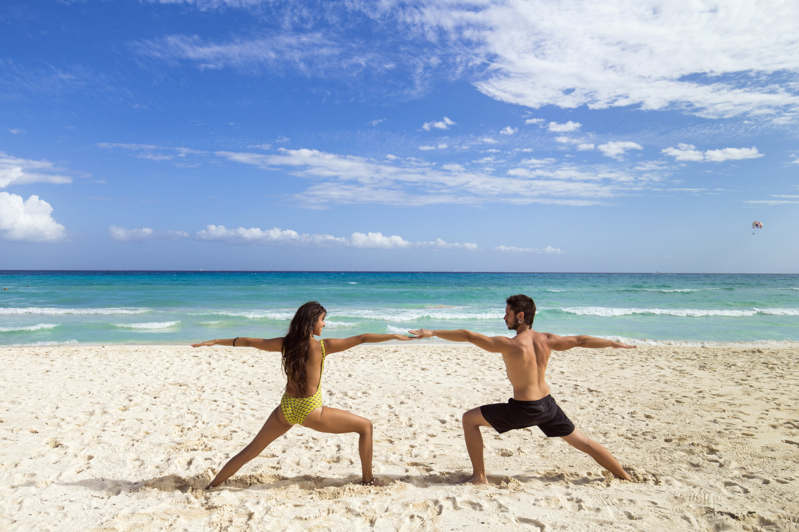 Couple practicing yoga together at the beach. Playa del Carmen, Mexico