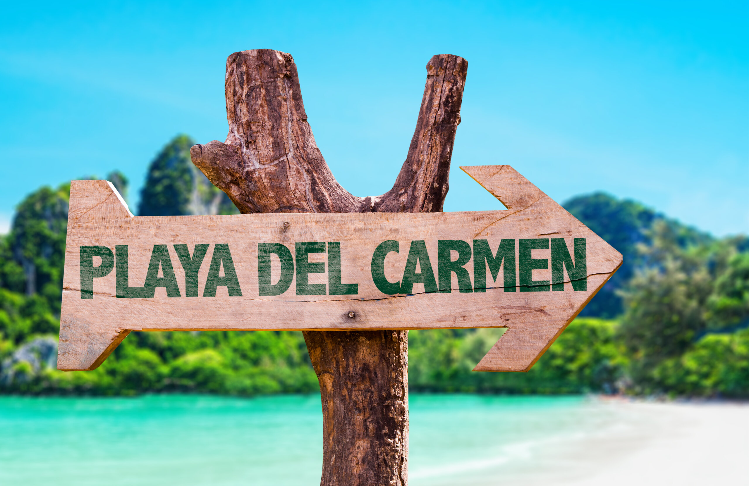 Playa Del Carmen wooden sign with beach background