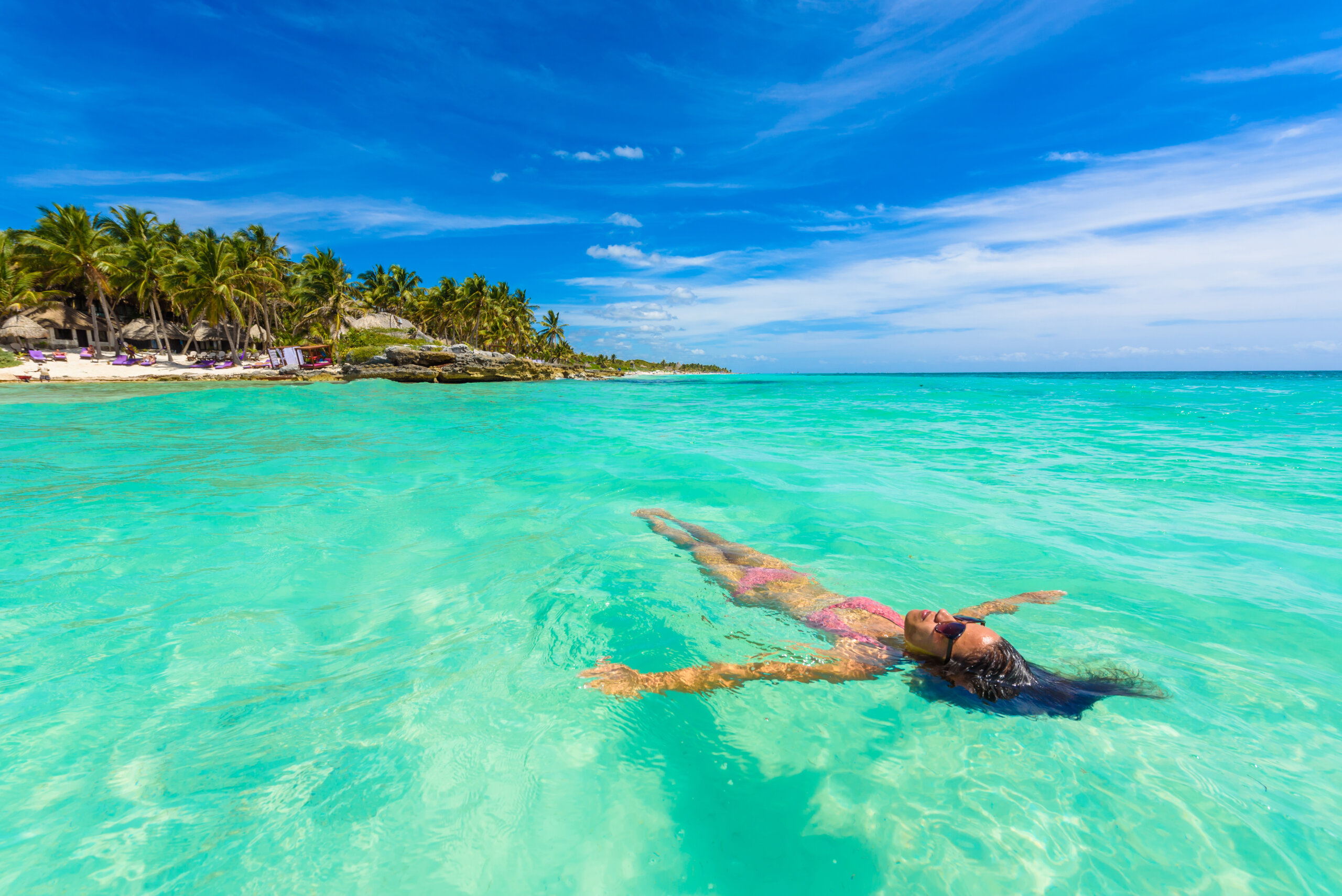 Atrakcyjna młoda kobieta relaks w turkusowych wodach Morza Karaibskiego przed rajskiej plaży w Tulum, blisko Cancun, Riviera Maya, Meksyk