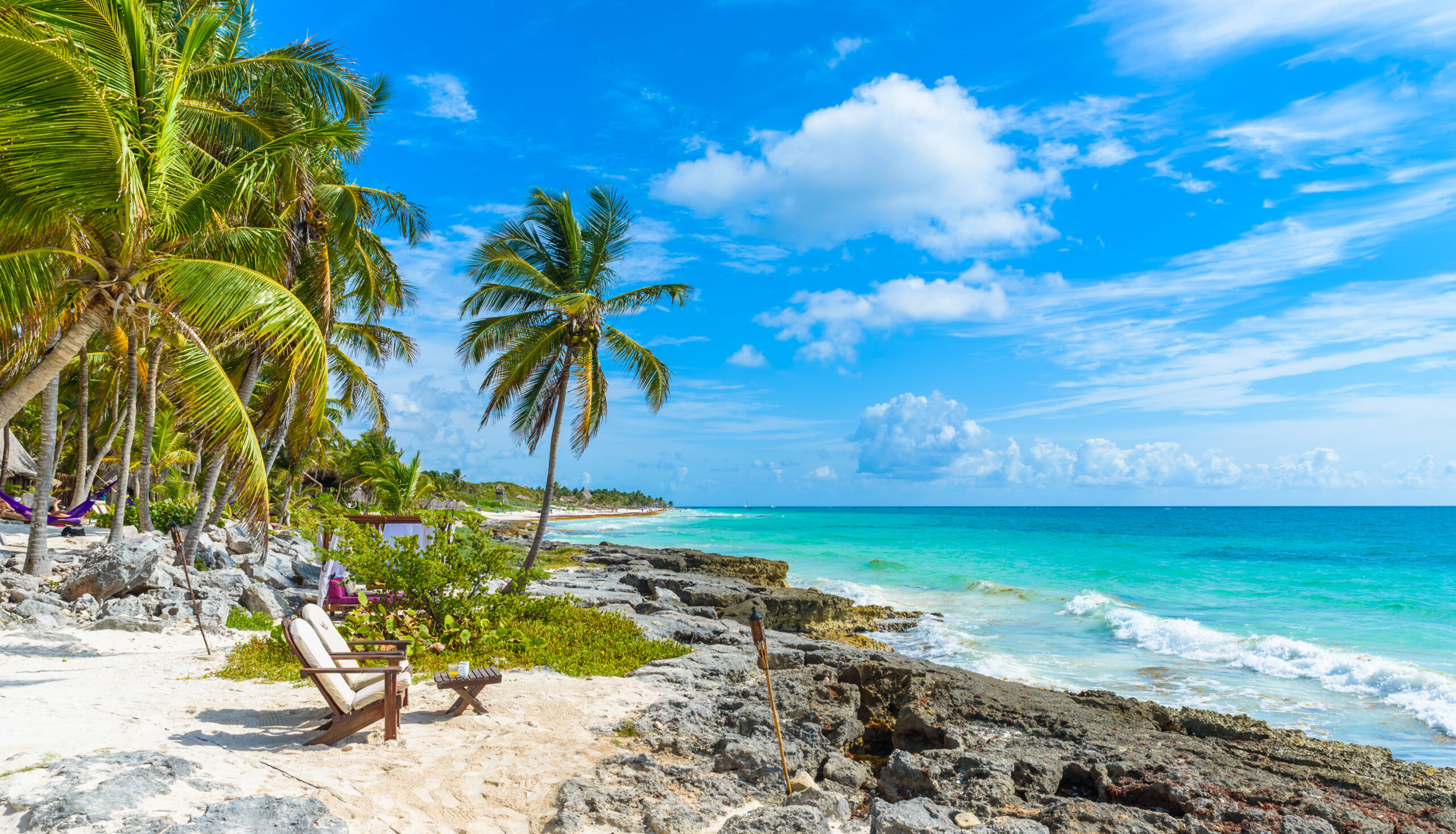 Krzesła pod palmami na rajskiej plaży w tropikalnym ośrodku. Riviera Maya - wybrzeże Karaibów w Tulum w Quintana Roo, Meksyk