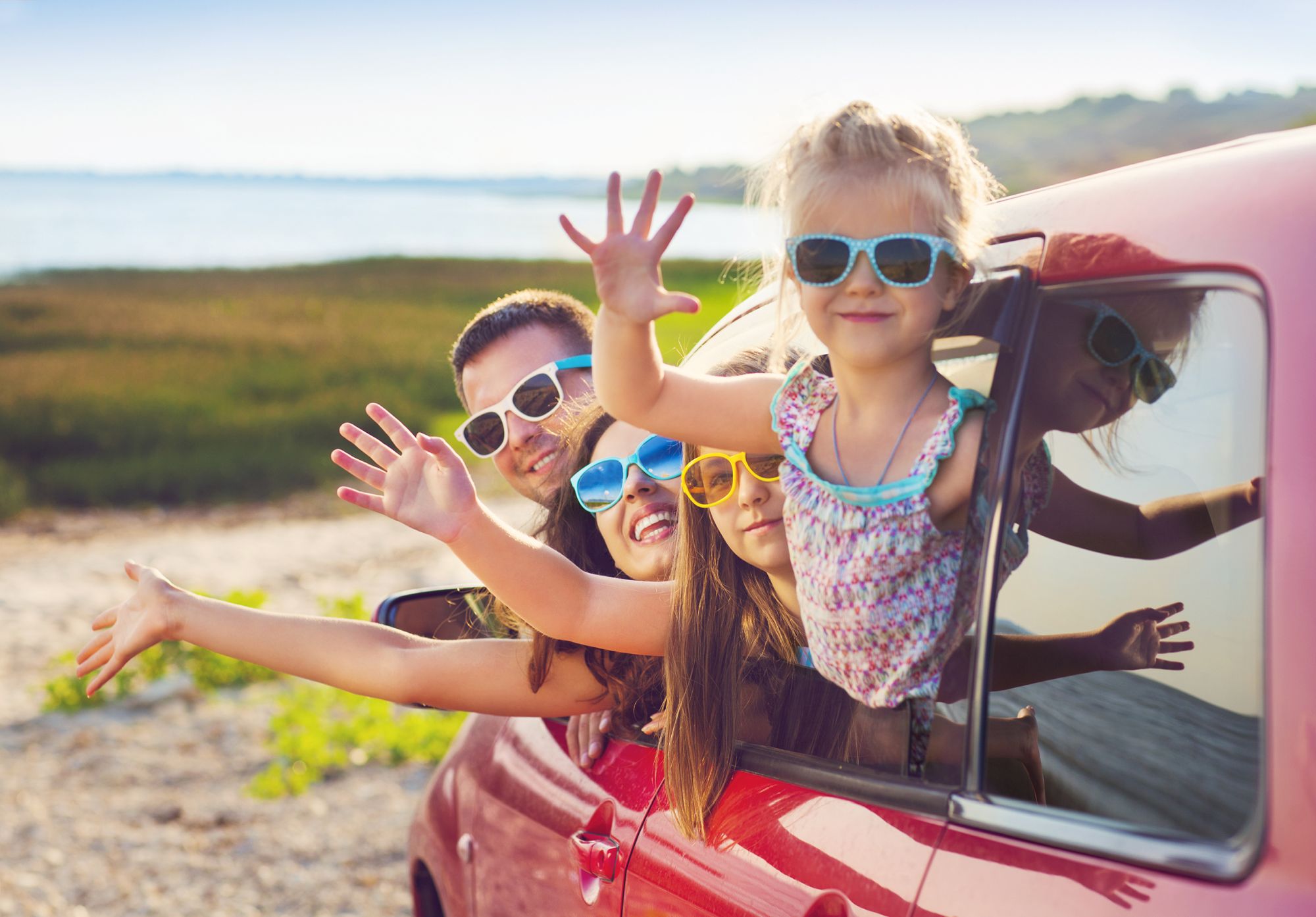 Portret uśmiechniętej rodziny z dwójką dzieci na plaży w samochodzie. Koncepcja wakacji i podróży